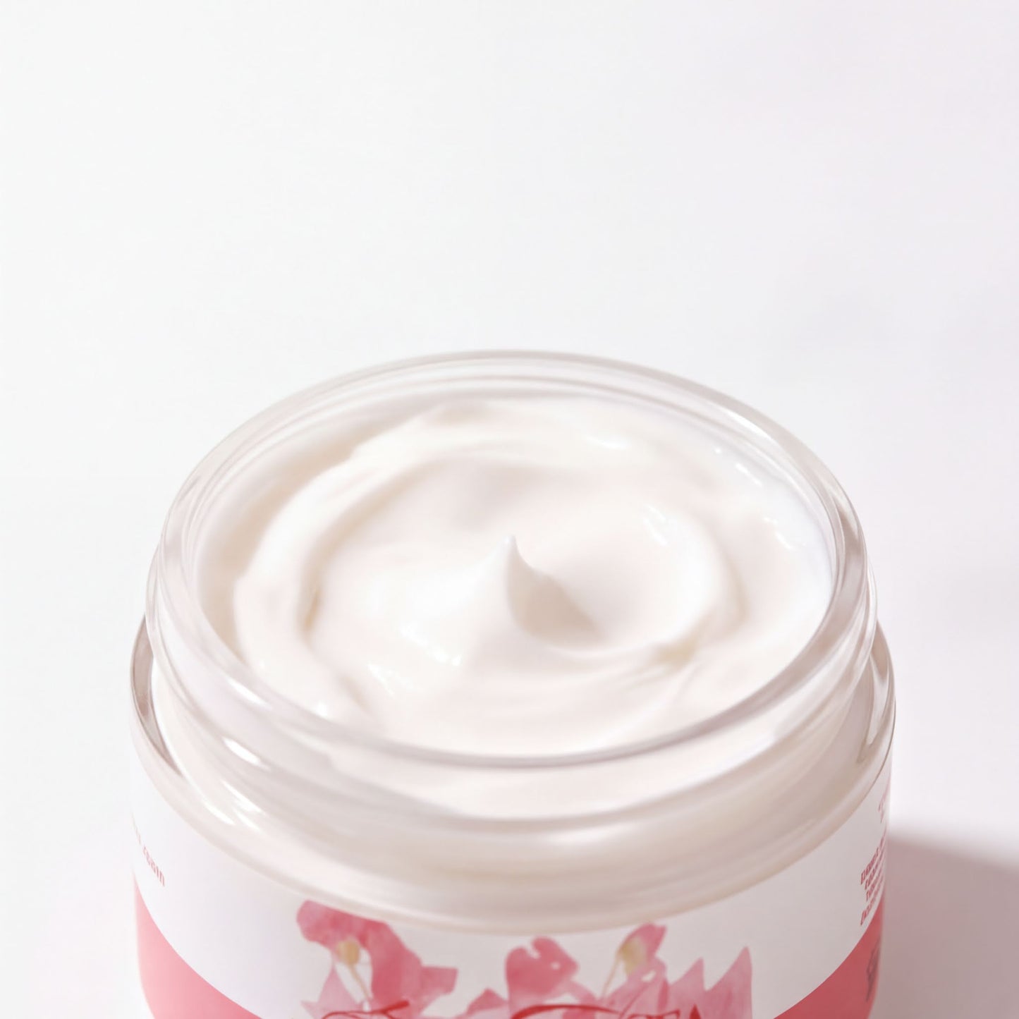 A jar of white cream with a pink floral design on the label.