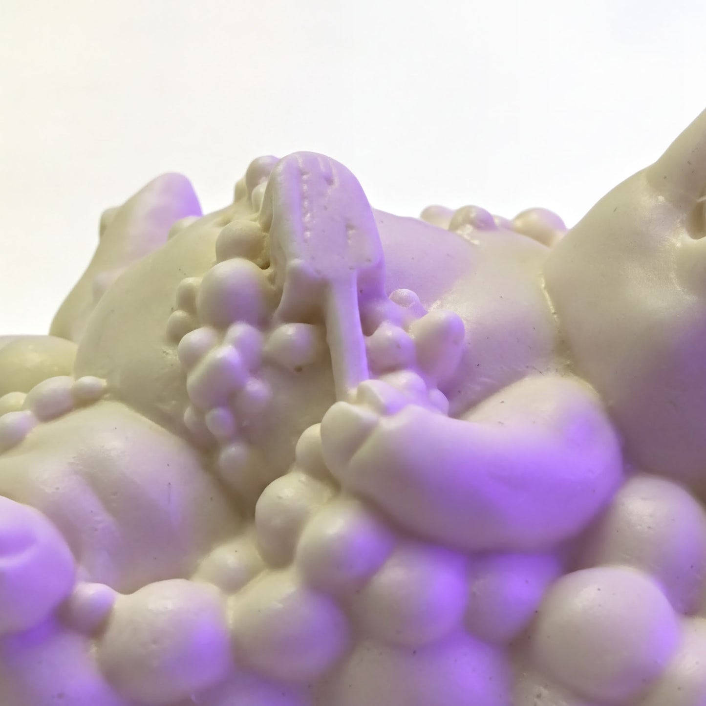 A close-up view of a white, foamy substance with a small object resembling a toothbrush or similar item in the center.