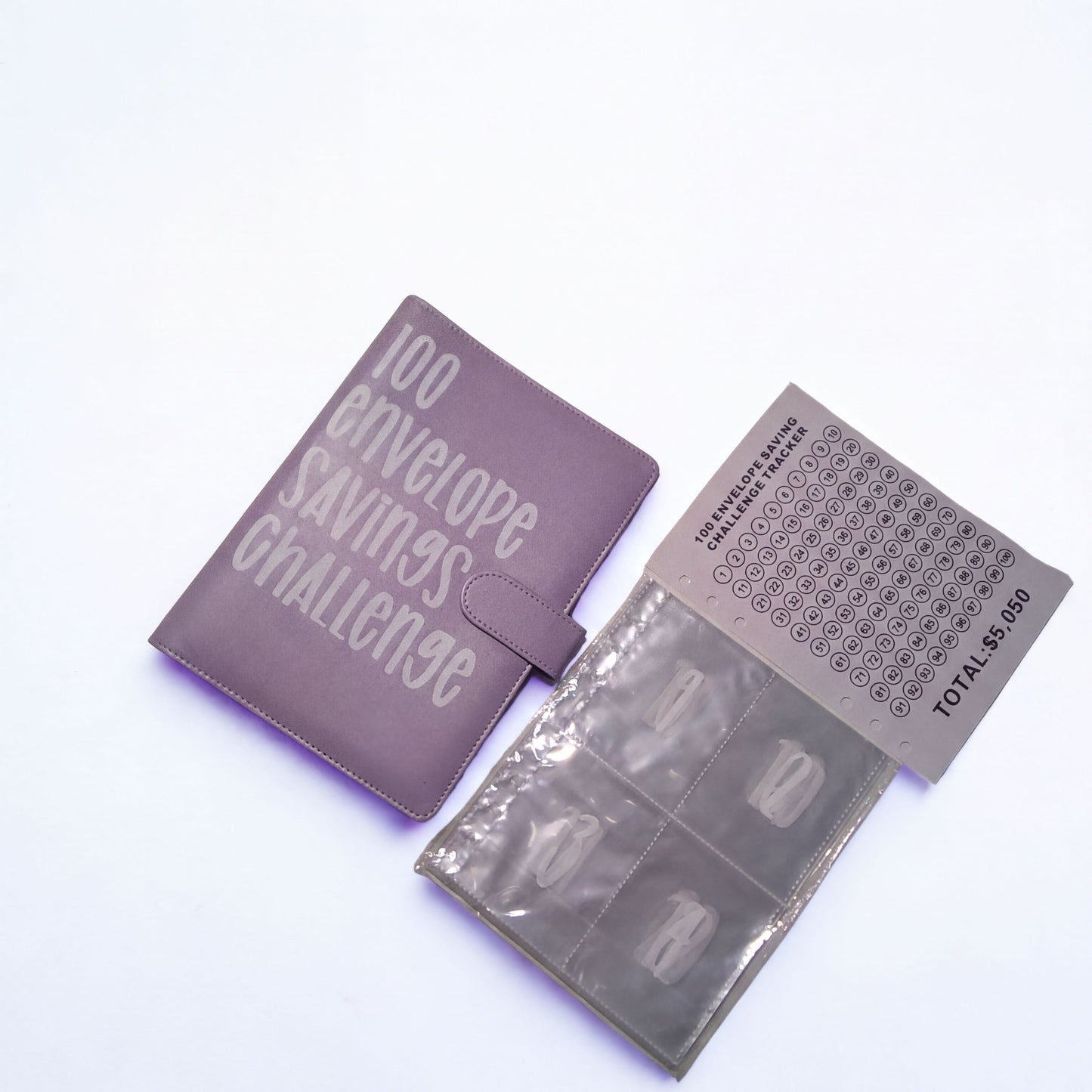a purple folder with the text "100 envelope savings challenge" printed on it, along with a matching purple folder and a matching purple folder with a chart or scoring system printed on it.
