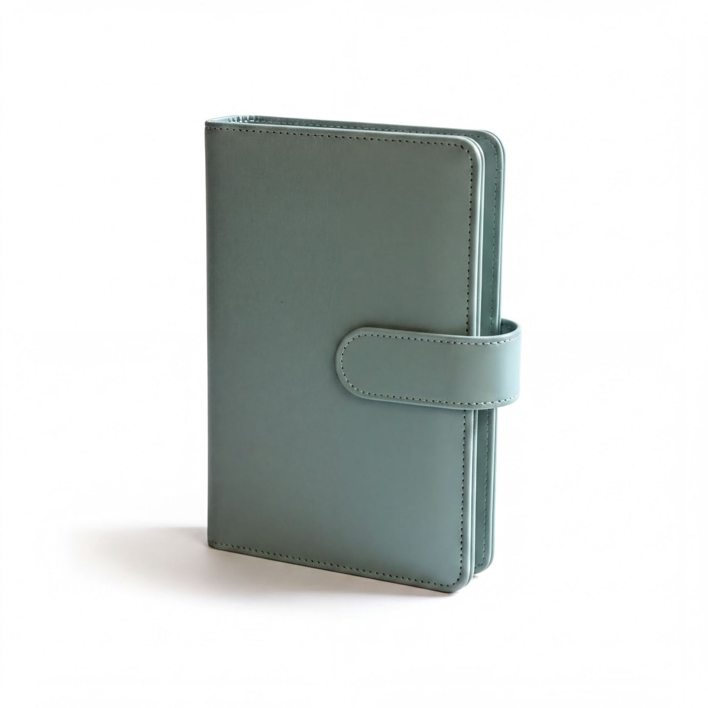 A light green leather-bound notebook or planner with a small leather clip on the cover.