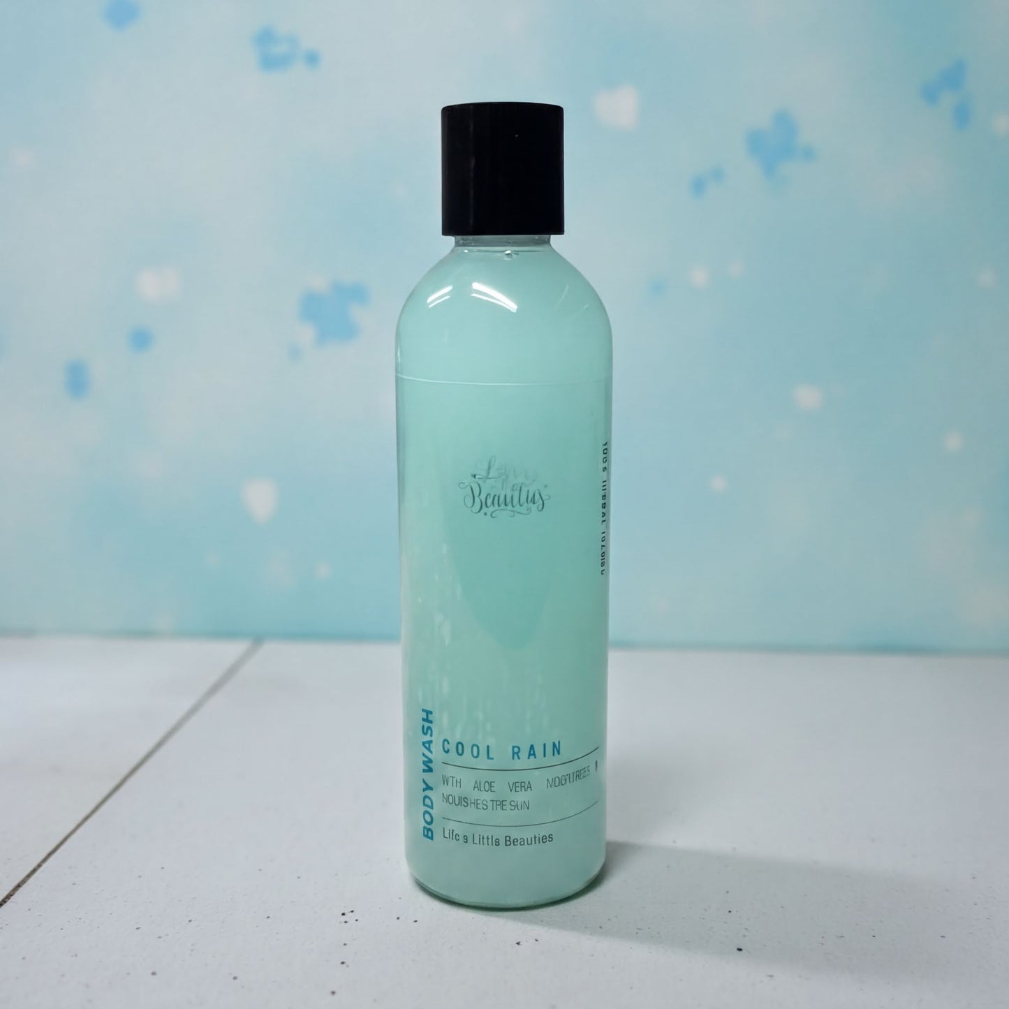 A bottle of "Cool Rain" body wash against a blue background.