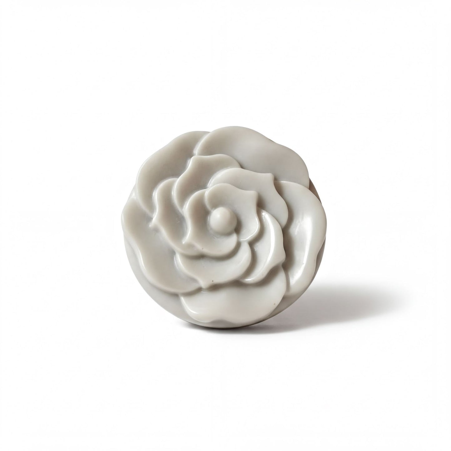 A white, round, flower-shaped object is shown against a white background.