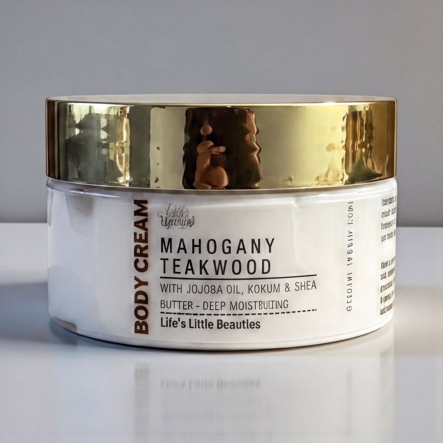 A jar of Mahogany Teakwood body cream with jojoba oil, kokum, and shea butter, with a gold lid.