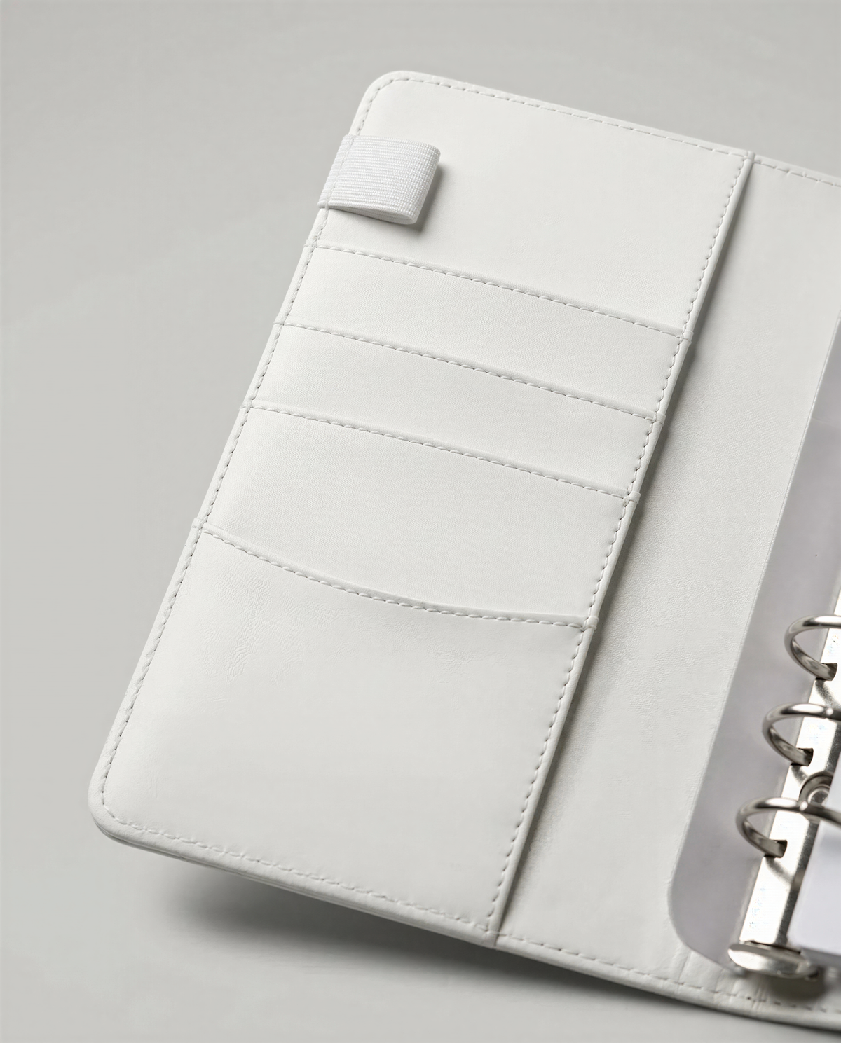A white leather wallet or card holder with multiple pockets and compartments.