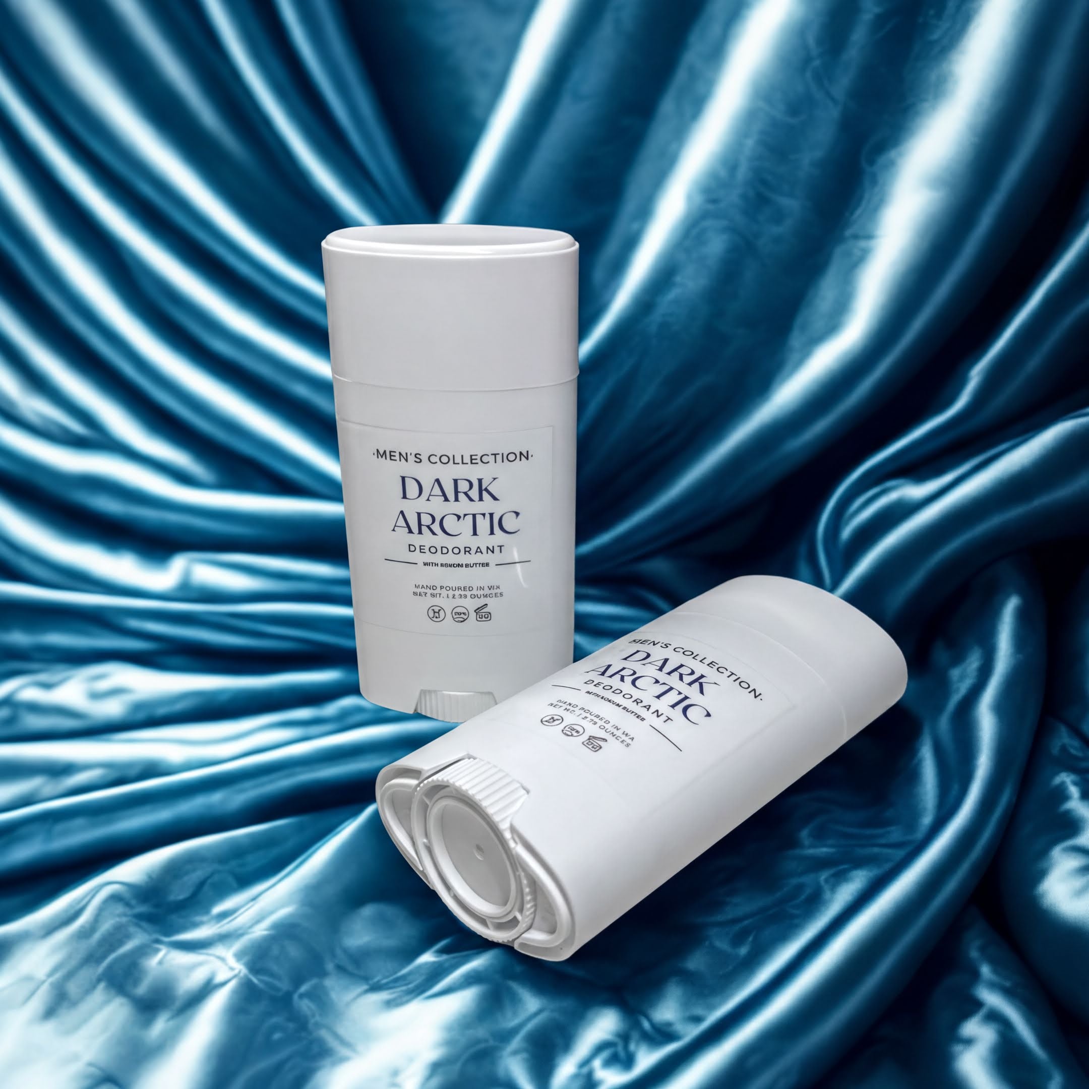 Two white deodorant sticks from Men's Collection Dark Arctic are shown against a blue fabric background.