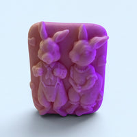 A pink soap bar with two cute rabbit-like figures on it.