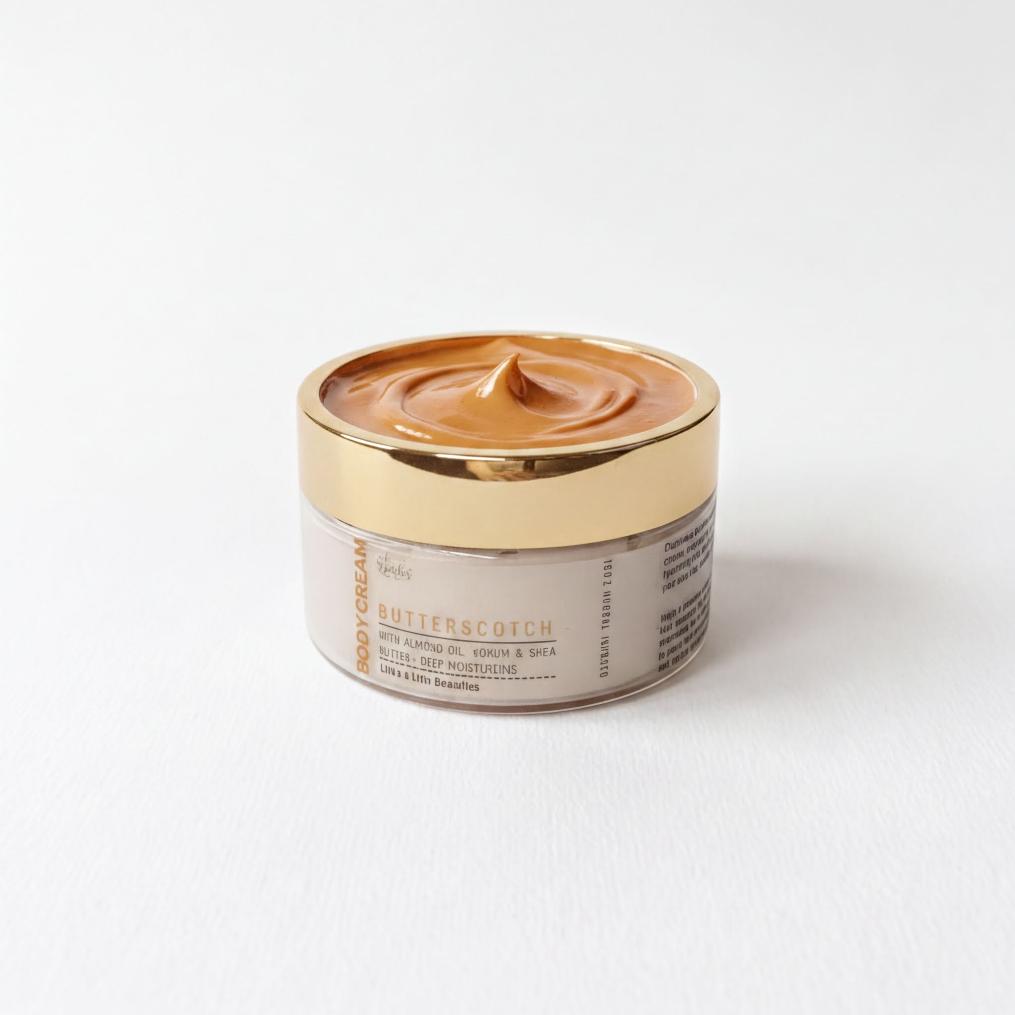 A jar of body cream with a golden lid, containing a light brown substance, is placed on a white background.