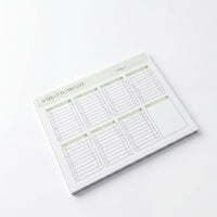 a white weekly to-do list with a green border, placed on a white surface.