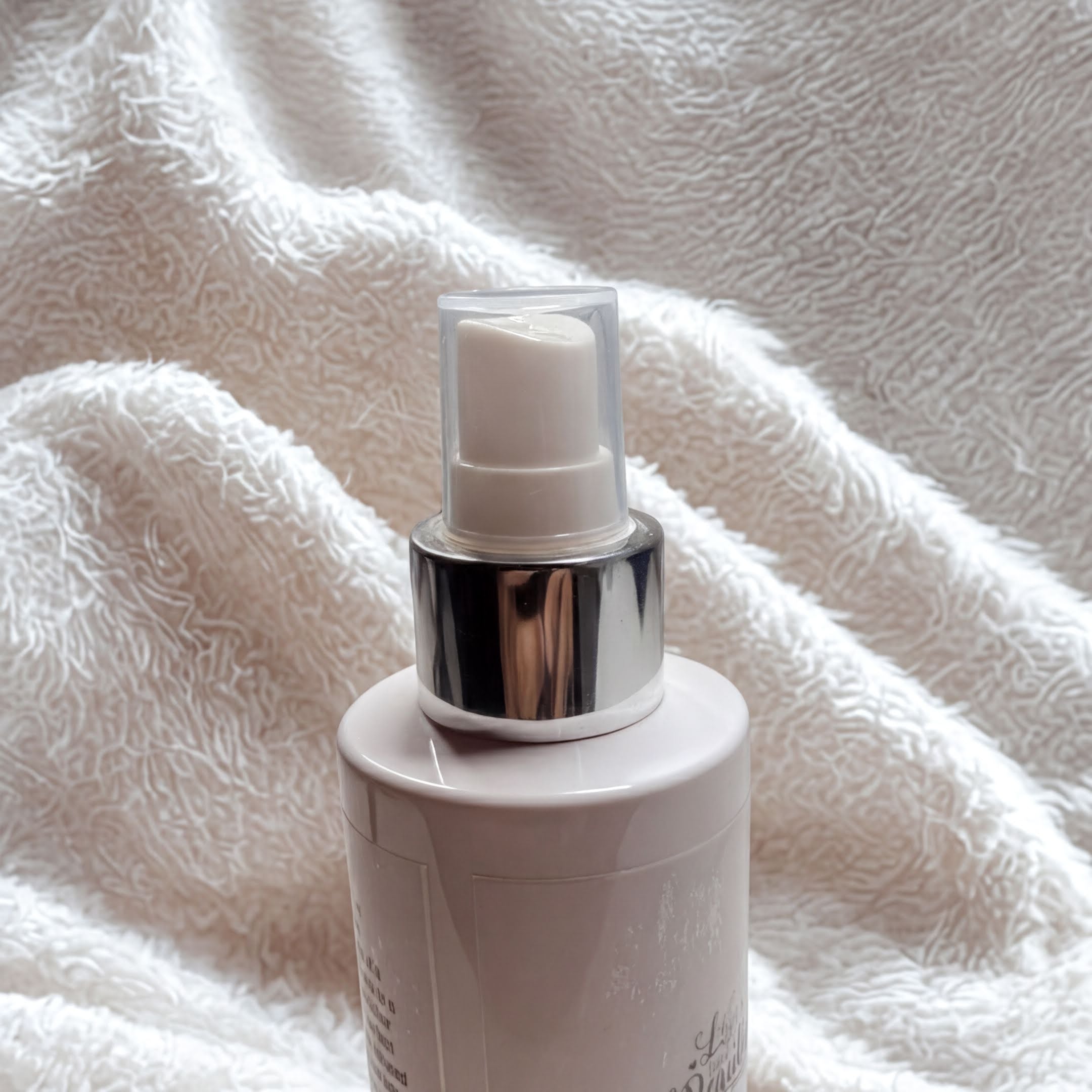 Natural oil spray with chrome pump on soft white towel, handcrafted with goat milk & natural ingredients