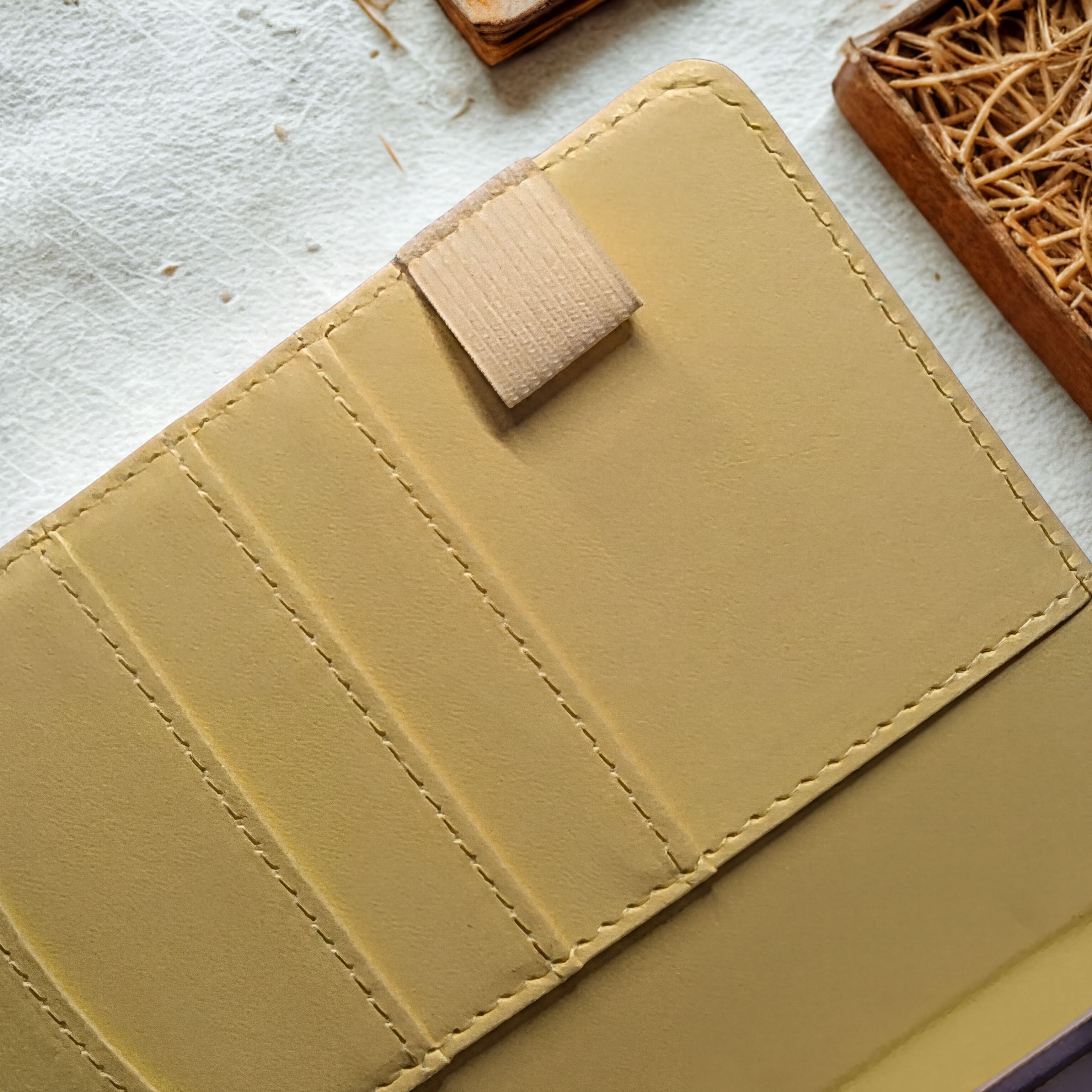 Tan leather wallet with card slots and snap closure, artisan-crafted with natural materials
