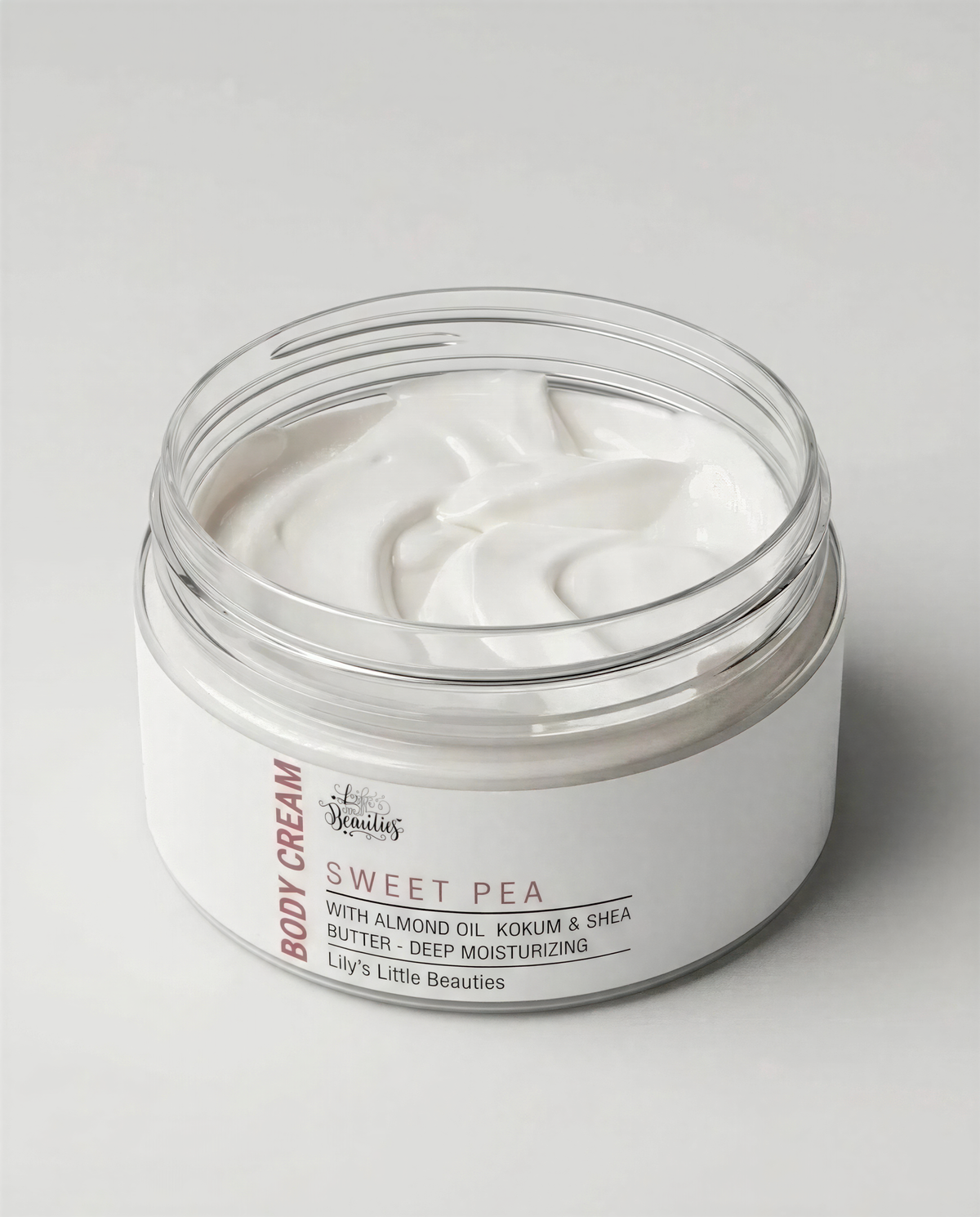 A jar of body cream with a white label that reads "Body Cream SWEET PEA" and includes ingredients such as almond oil, kokum & shea butter, and deep moisturizing.