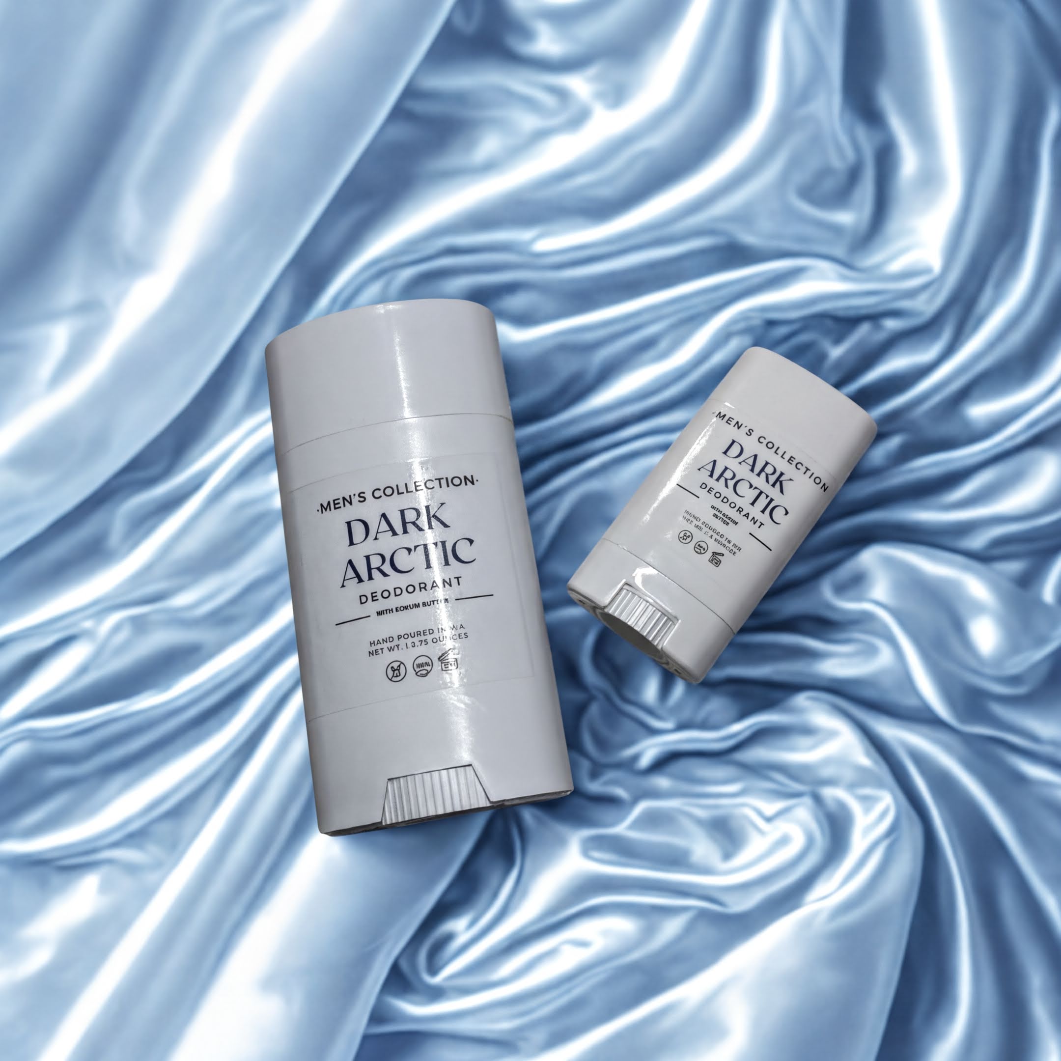 Two deodorant sticks are placed on a blue fabric background.