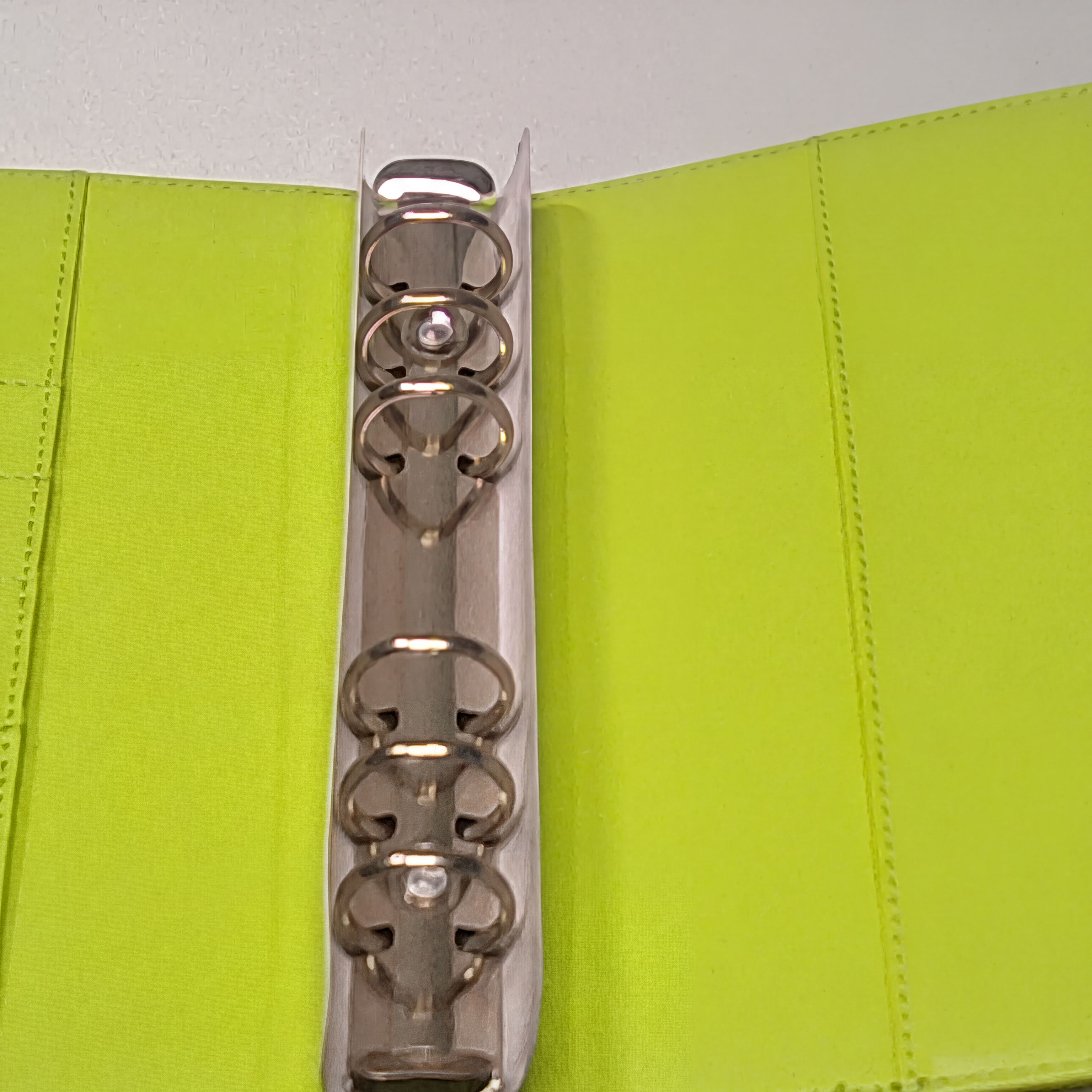 Lime green fabric binder with silver metal rings and stitching detail