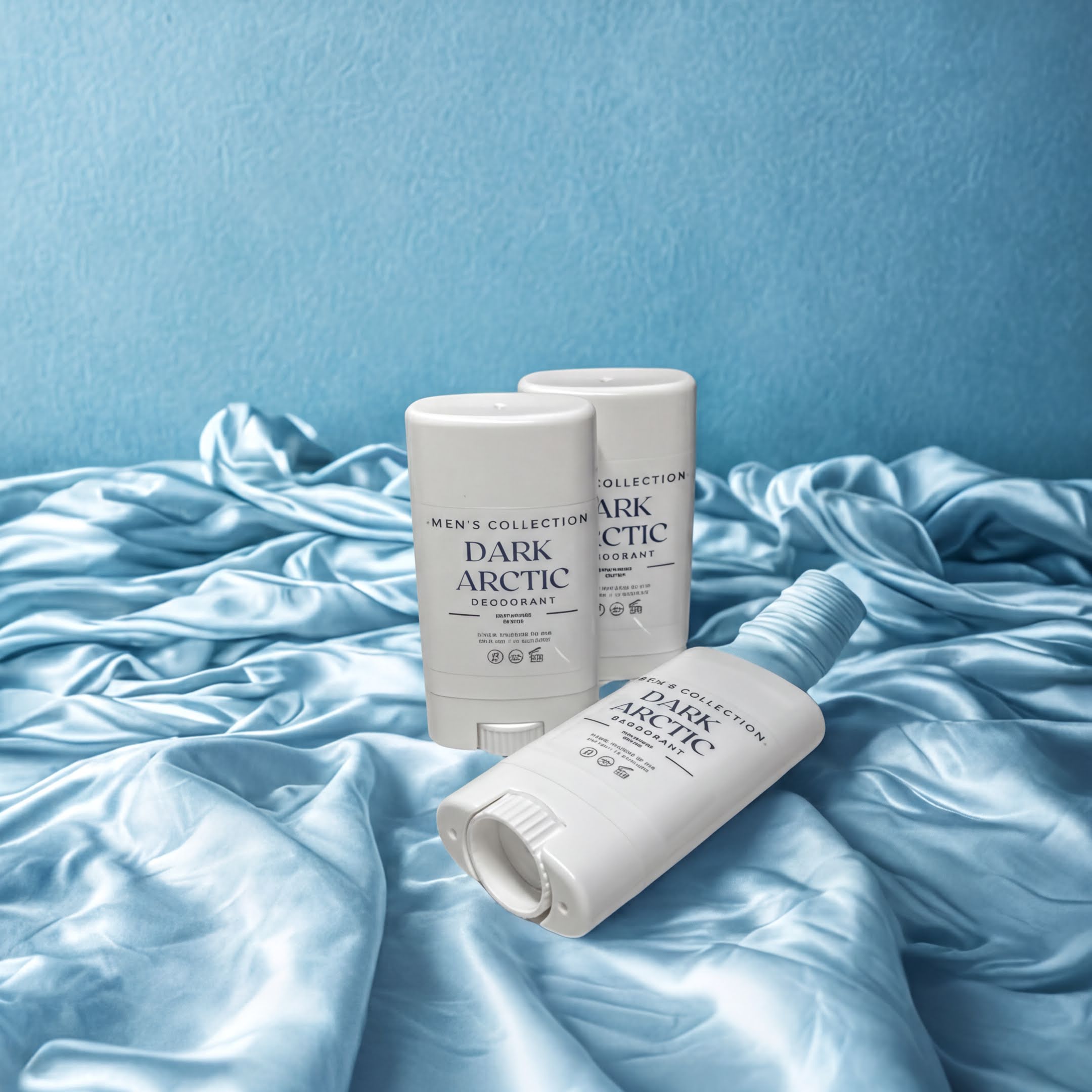 Three white deodorant sticks with blue text are placed on a blue fabric background.