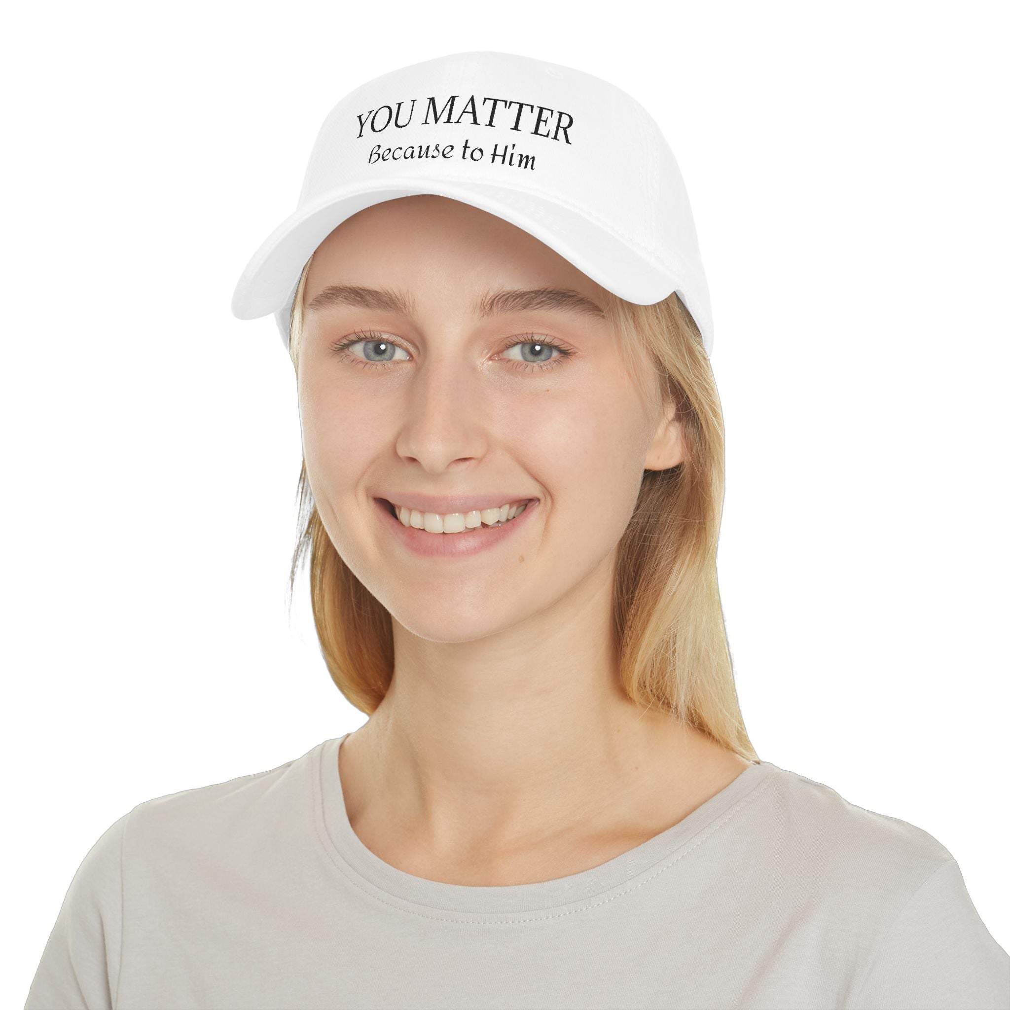 White cap with 'YOU MATTER Because to Him' text, worn by smiling woman