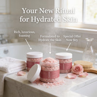 three jars of pink bath salt on a marble countertop, with a rose petal on the countertop and a bottle of lotion nearby.