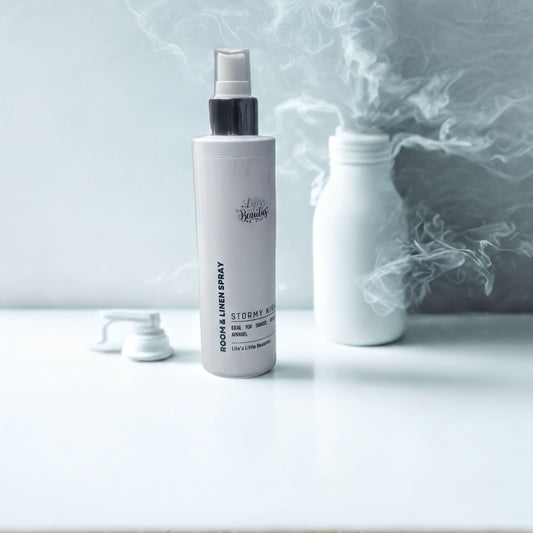 A bottle of "Stormy Night" hair spray is placed on a white bathroom counter, with a folded white towel and a vase of white flowers nearby.