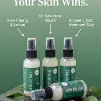 three bottles of lotion and lotion spray, with a green background and some leaves on a black surface.