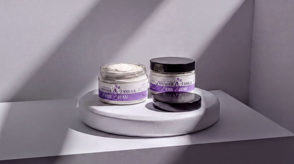 Two jars of lavender and vanilla body cream are placed on a white pedestal against a white wall, with sunlight casting shadows on the pedestal.