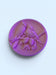 A purple ceramic plate with a detailed bird carving design on it.