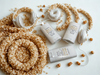 a collection of items related to honey and oatmeal, including two white deodorant sticks, a pair of white headphones, and some honeycomb-like objects.
