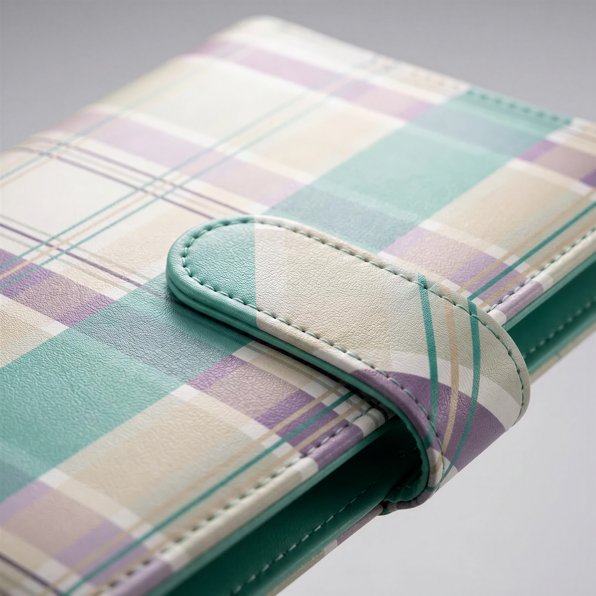 A close-up image of a colorful plaid wallet or card holder with a green and purple pattern.