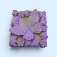 A square soap with a purple butterfly design on it.