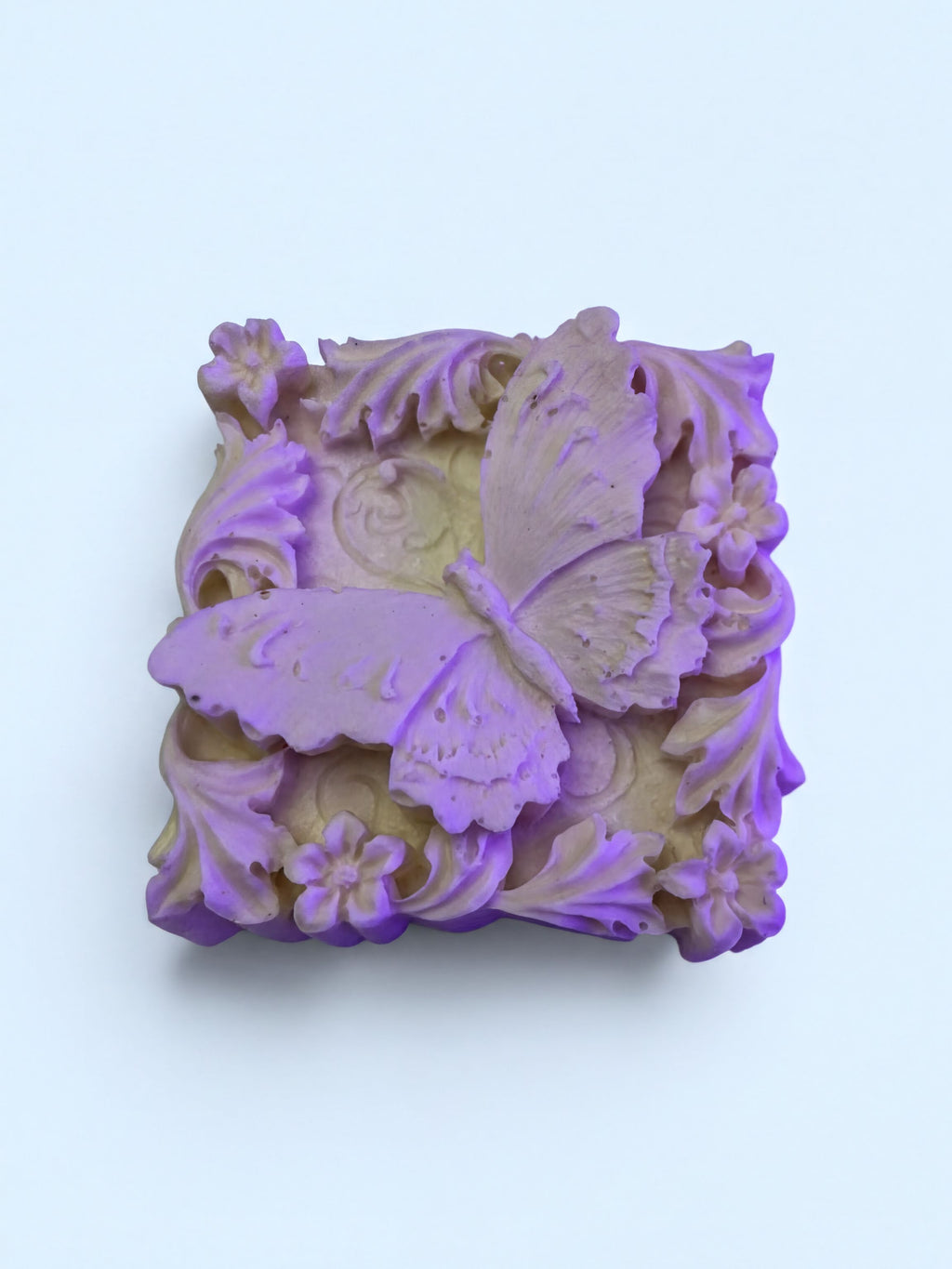 A square soap with a purple butterfly design on it.