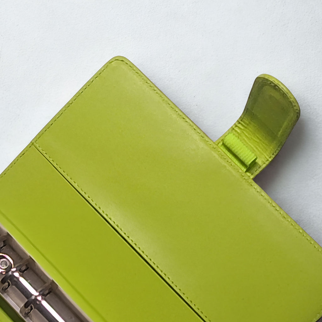 Lime green leather notebook cover with snap closure and stitching detail