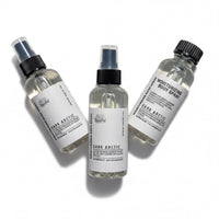 Three bottles of body spray with black caps and white labels, each containing a different scent.