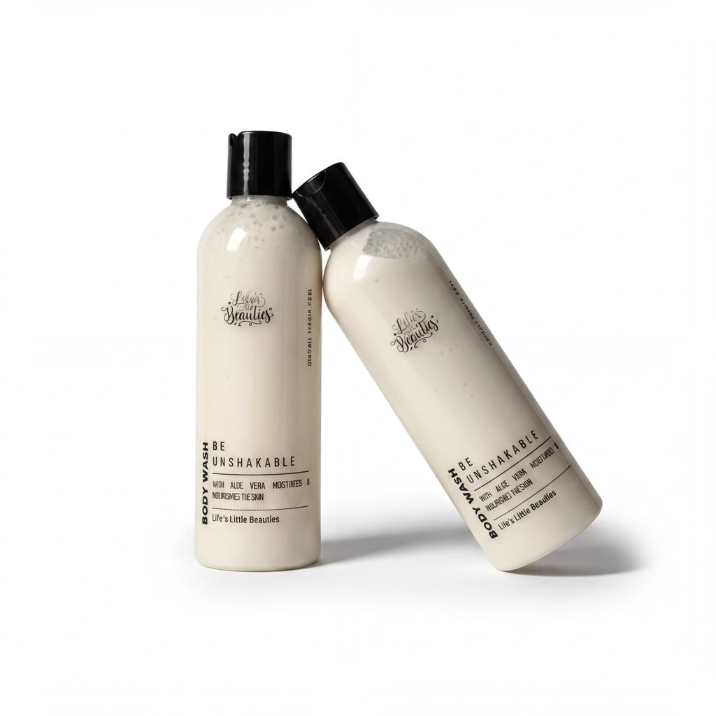 Two bottles of body wash with black caps and white labels, leaning against each other.