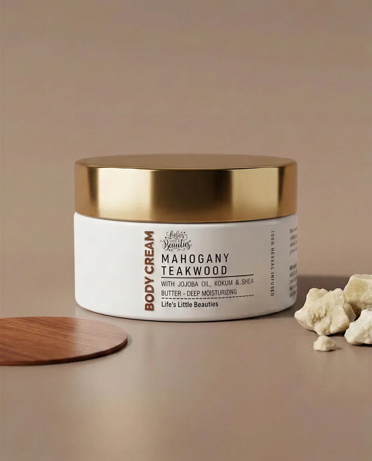 A jar of body cream with a gold lid, labeled "Mahogany Teakwood" and containing "Buttermilk & Shea Butter".