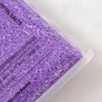 a close-up view of a container filled with purple bath salt crystals.