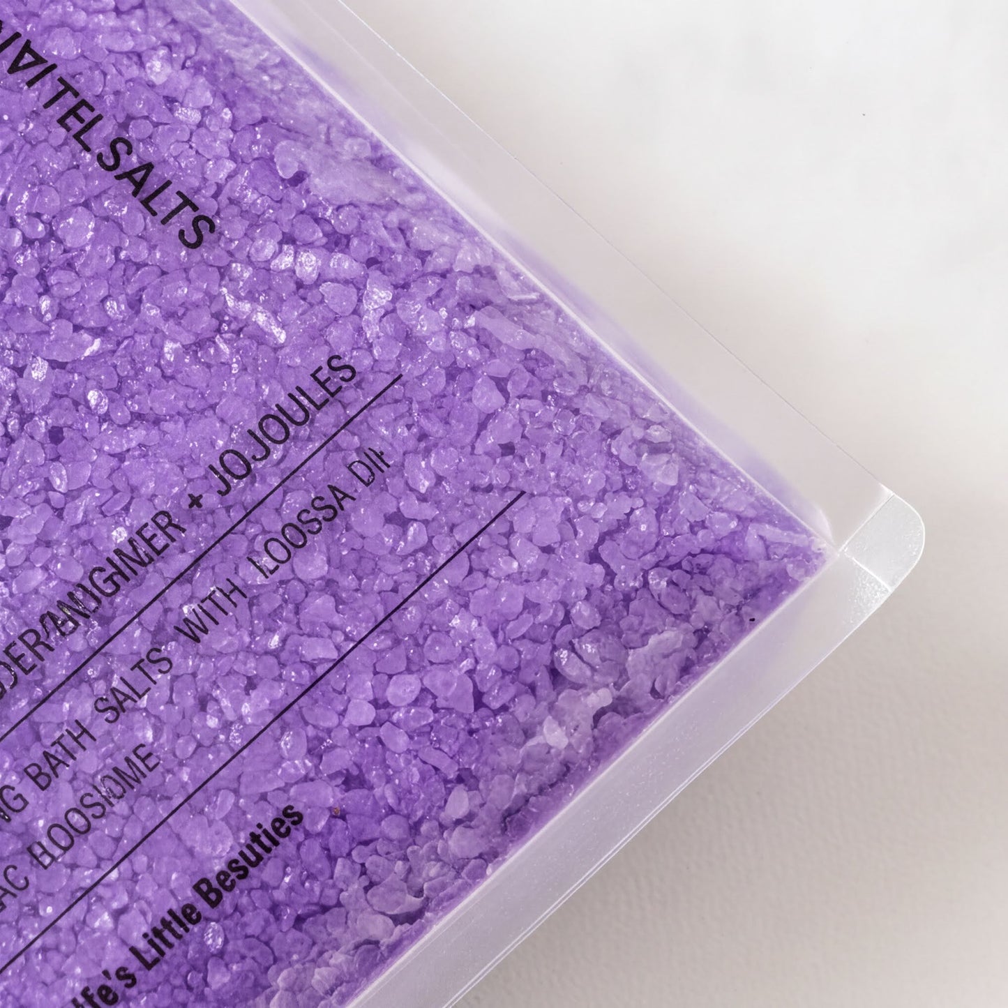 a close-up view of a container filled with purple bath salt crystals.