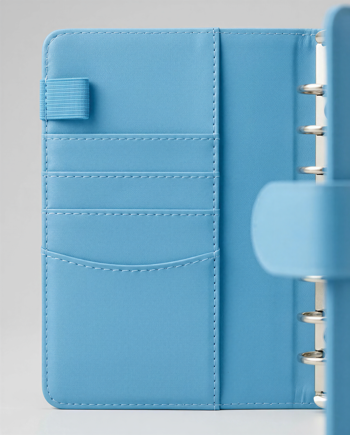 A close-up view of a light blue leather wallet or card holder with multiple pockets and compartments.