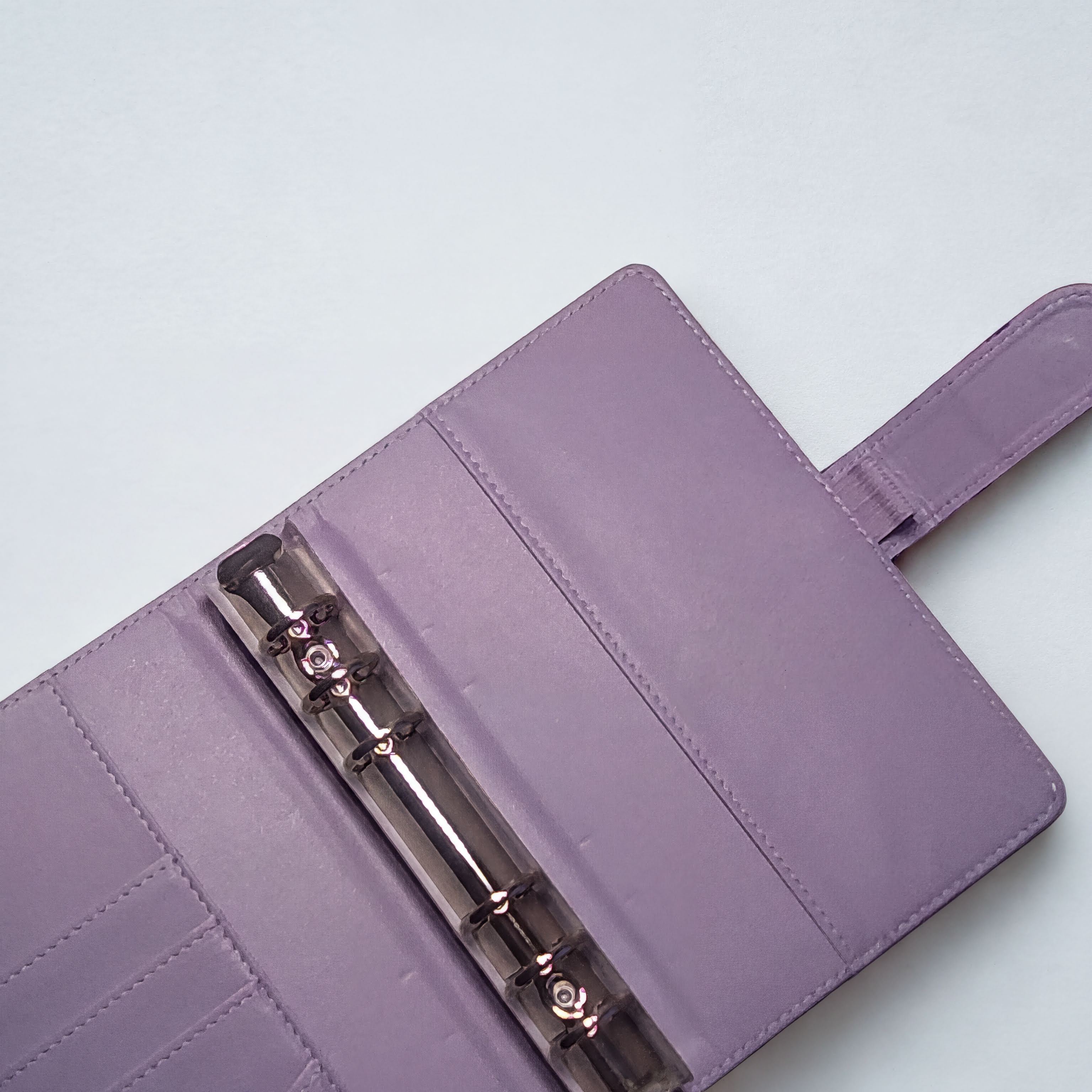 Purple leather planner with clear ring binder and stitching details