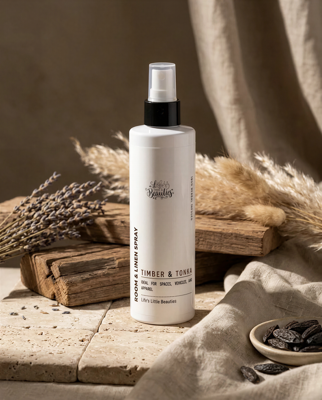 a bottle of "Lets Lendlin's" room and linen spray placed on a wooden surface, surrounded by dried lavender and pampas grass.