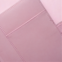A close-up view of a pink fabric, possibly a piece of clothing or a decorative item, with a small pocket visible.