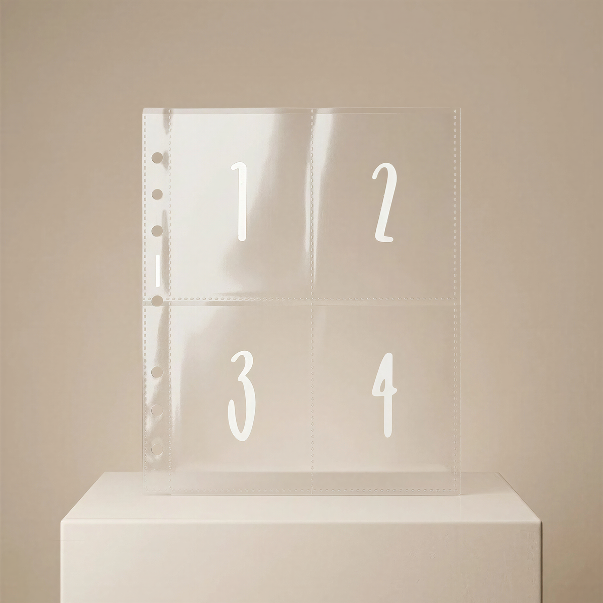 A clear plastic page with the numbers 1, 2, and 3 printed on it, placed on a white surface against a beige background.