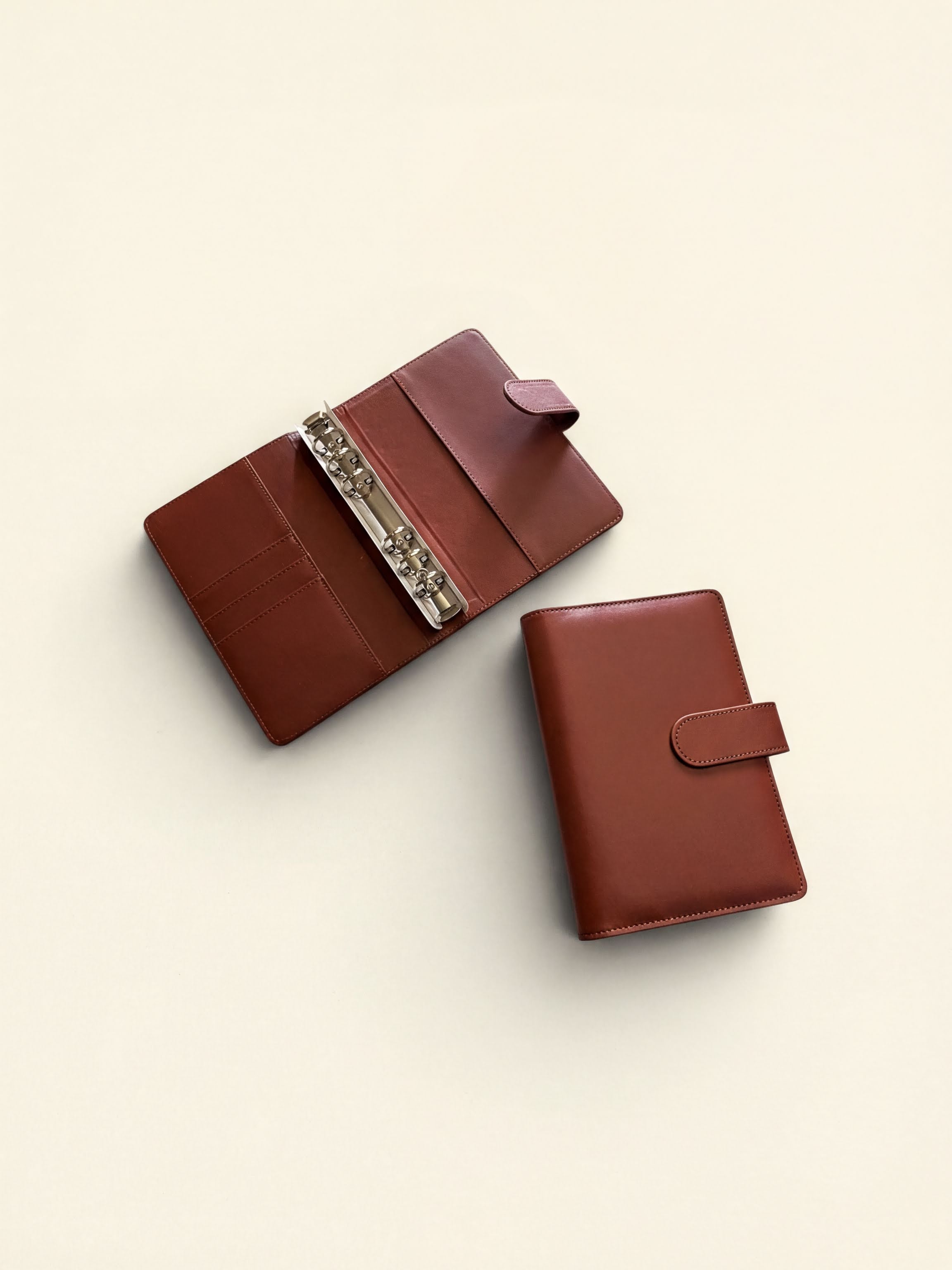 Two brown leather wallets are shown on a light background.