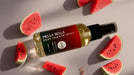 a bottle of Mella Bella Post-Shower Spray surrounded by slices of watermelon on a white background.