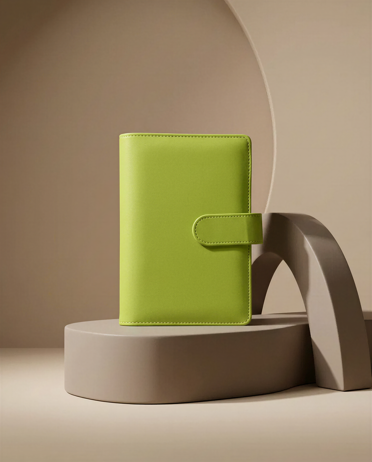 A bright green leather wallet or book cover is displayed on a gray pedestal against a beige background.