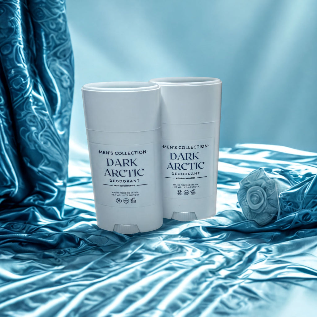 Two white deodorant sticks with black text are placed on a blue fabric surface, with a blue curtain in the background.