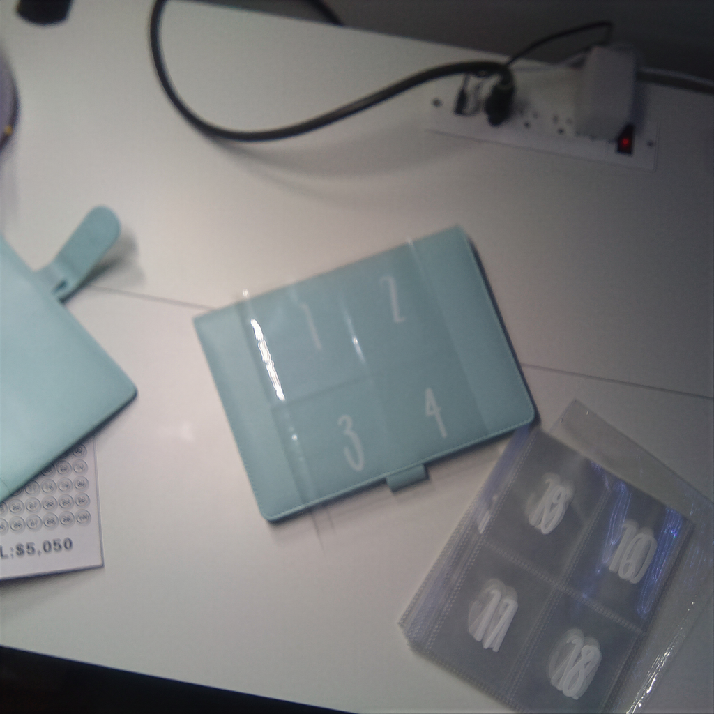 Light blue numbered tablet case and clear organizer on white desk with cables