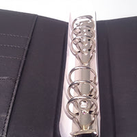 a close-up view of a metal ring mechanism, with the rings visible and the mechanism itself open.