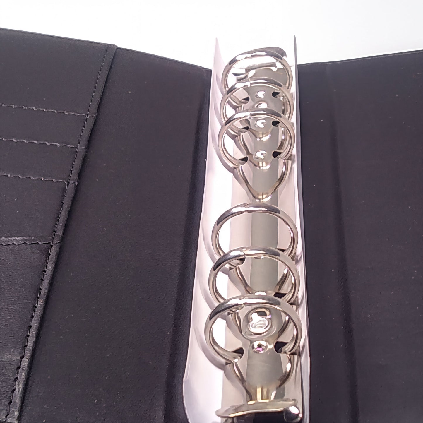a close-up view of a metal ring mechanism, with the rings visible and the mechanism itself open.