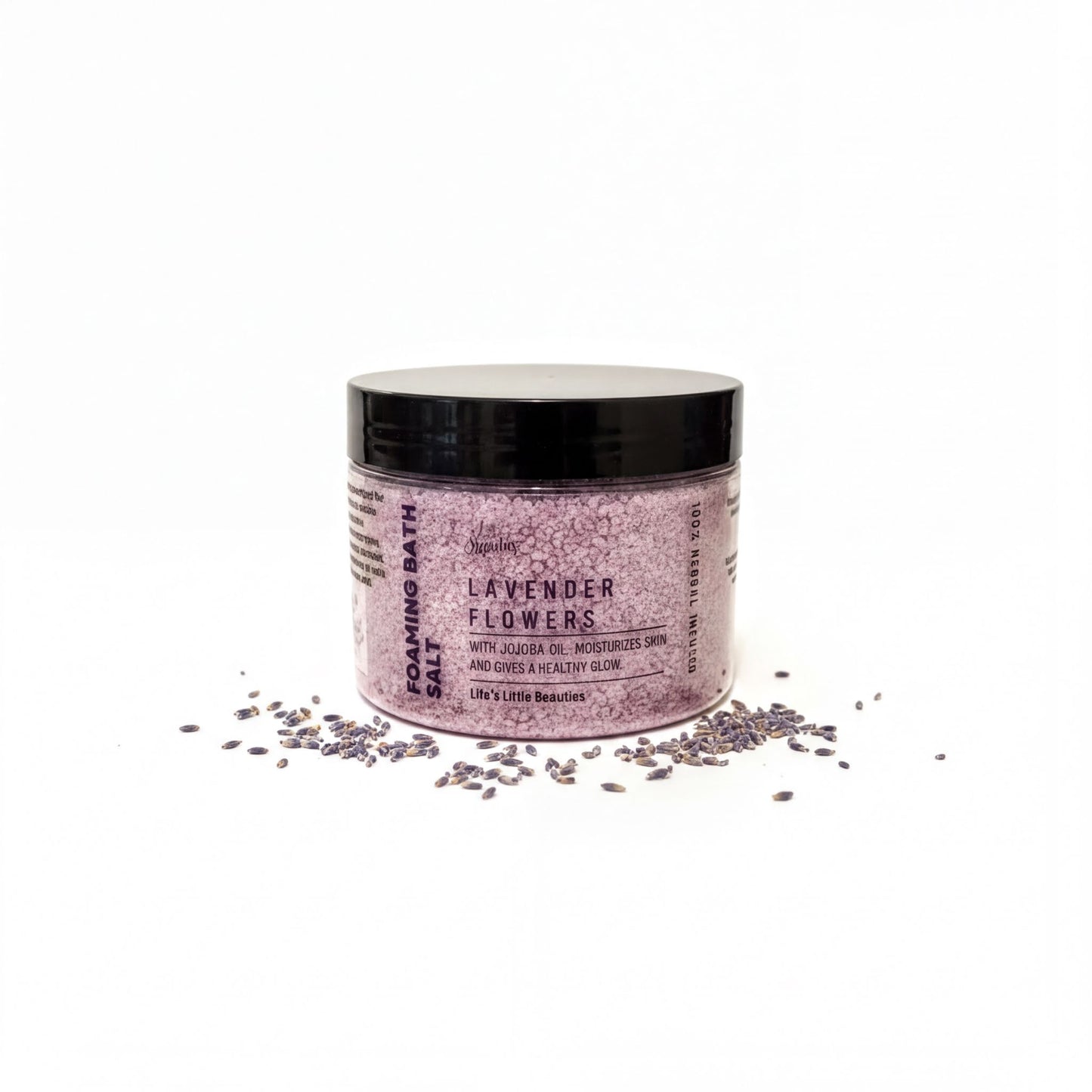 A jar of lavender bath salt surrounded by scattered lavender petals on a white background.