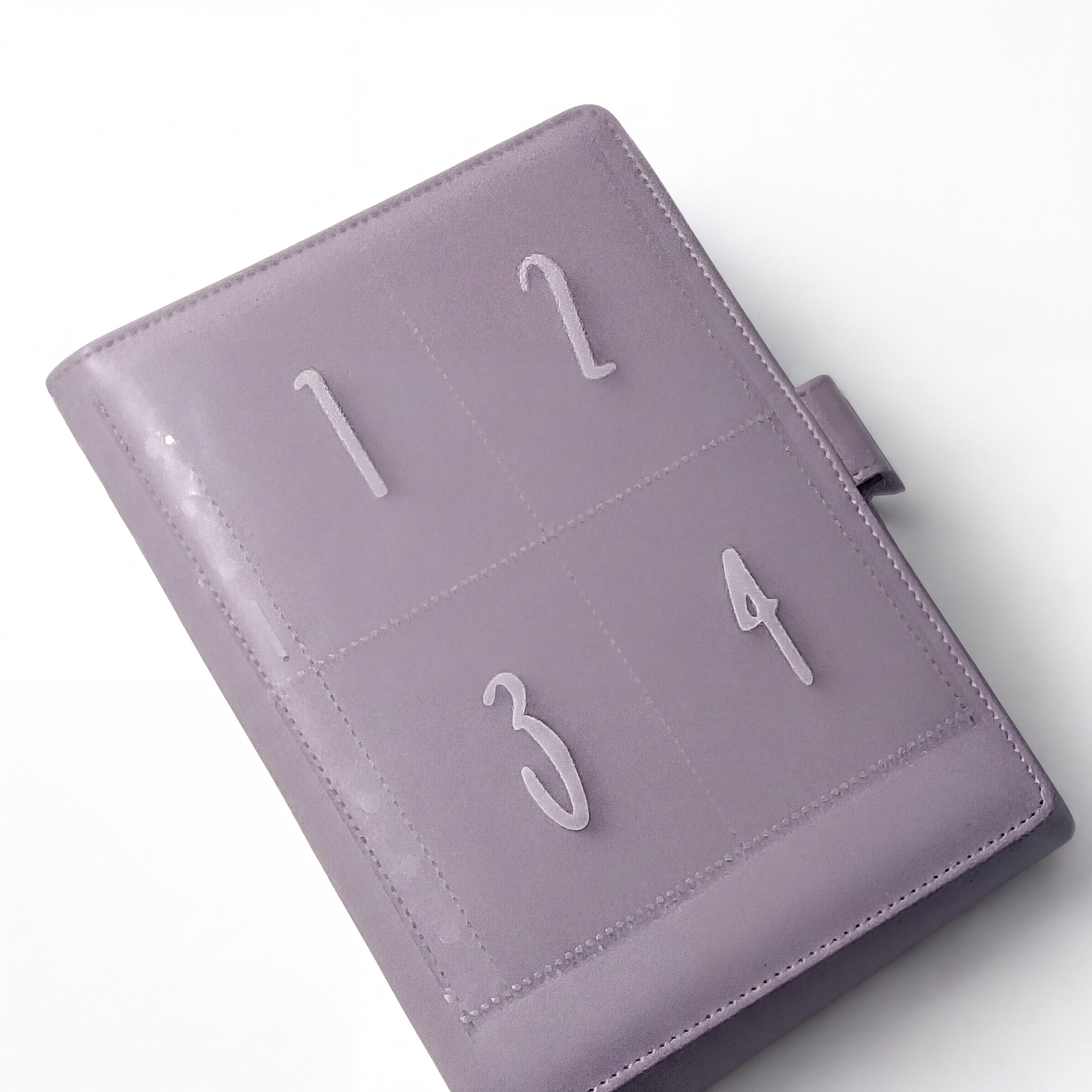 A purple leather-bound notebook or planner with numbered pages, including the numbers 1, 2, 3, and 4.