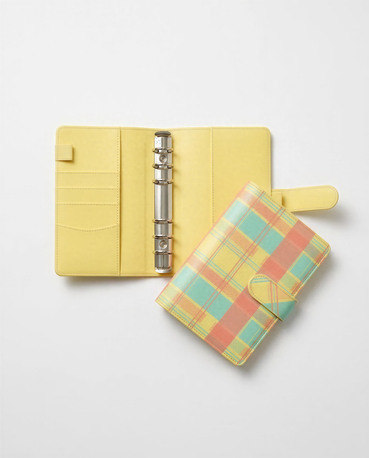 a yellow leather binder and a colorful plaid wallet placed on a white background.