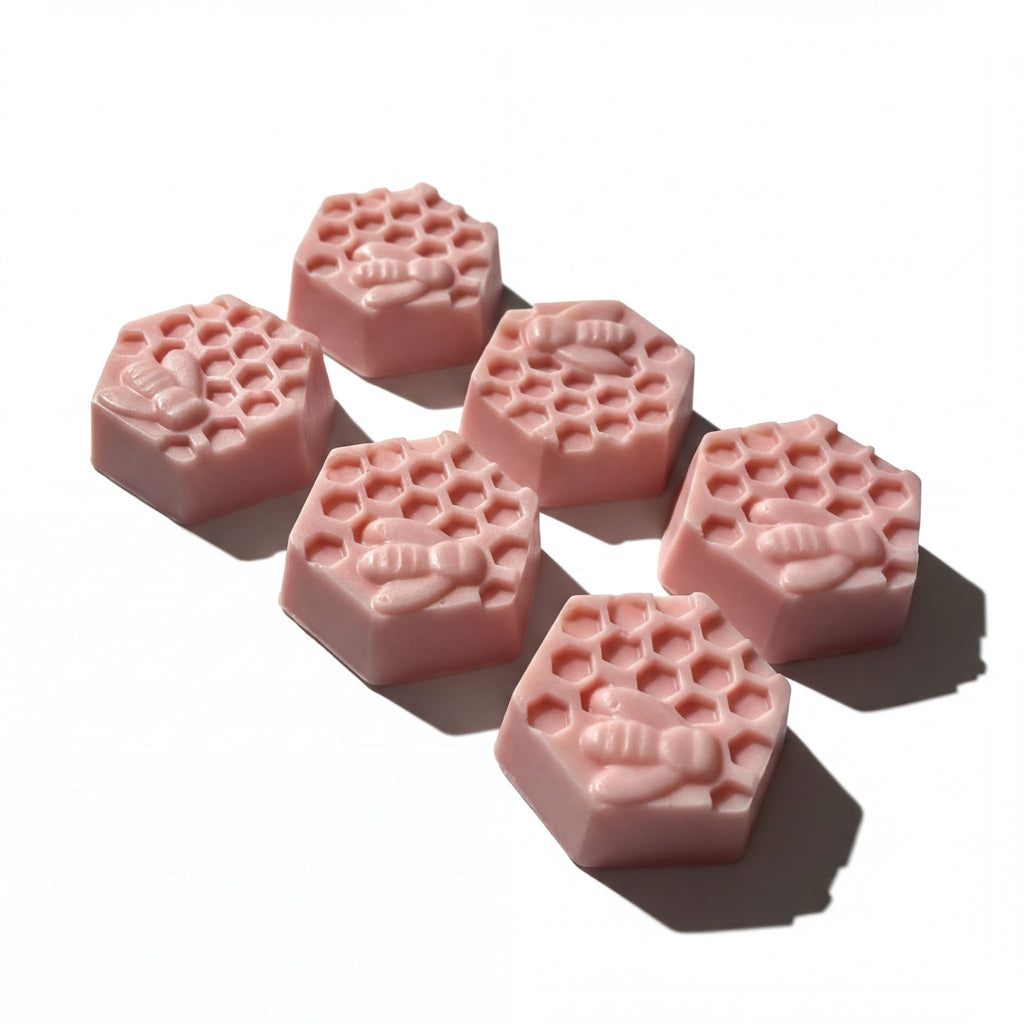 Handcrafted pink goat milk soap bars with honeycomb and bee design, made with natural ingredients